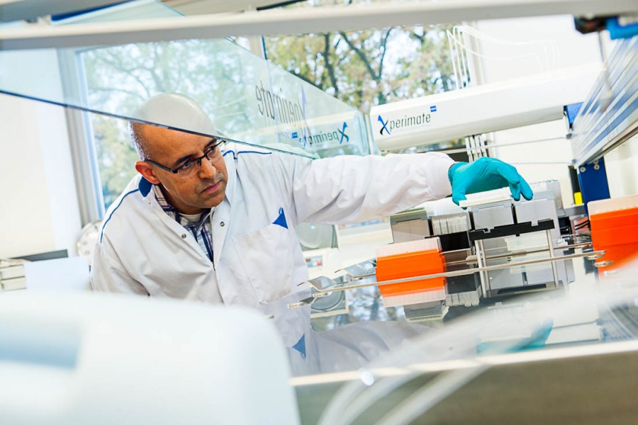 geconcentreerde laborant vult monsters in analyseapparaat